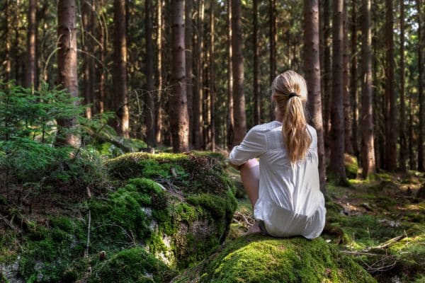 Woman Sitting In Green Forest Enjoys The Silence And Beauty